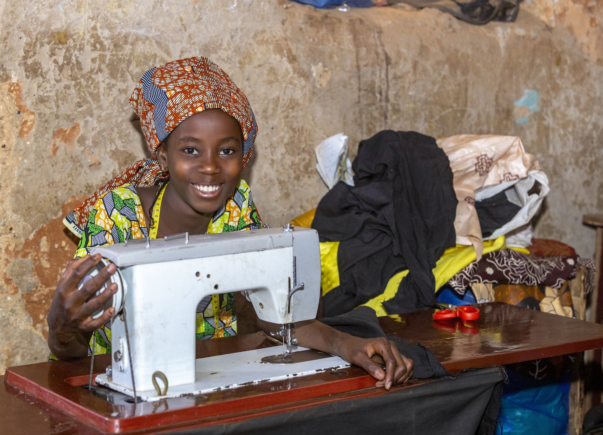Una giovane donna siede alla macchina da cucire in Niger.