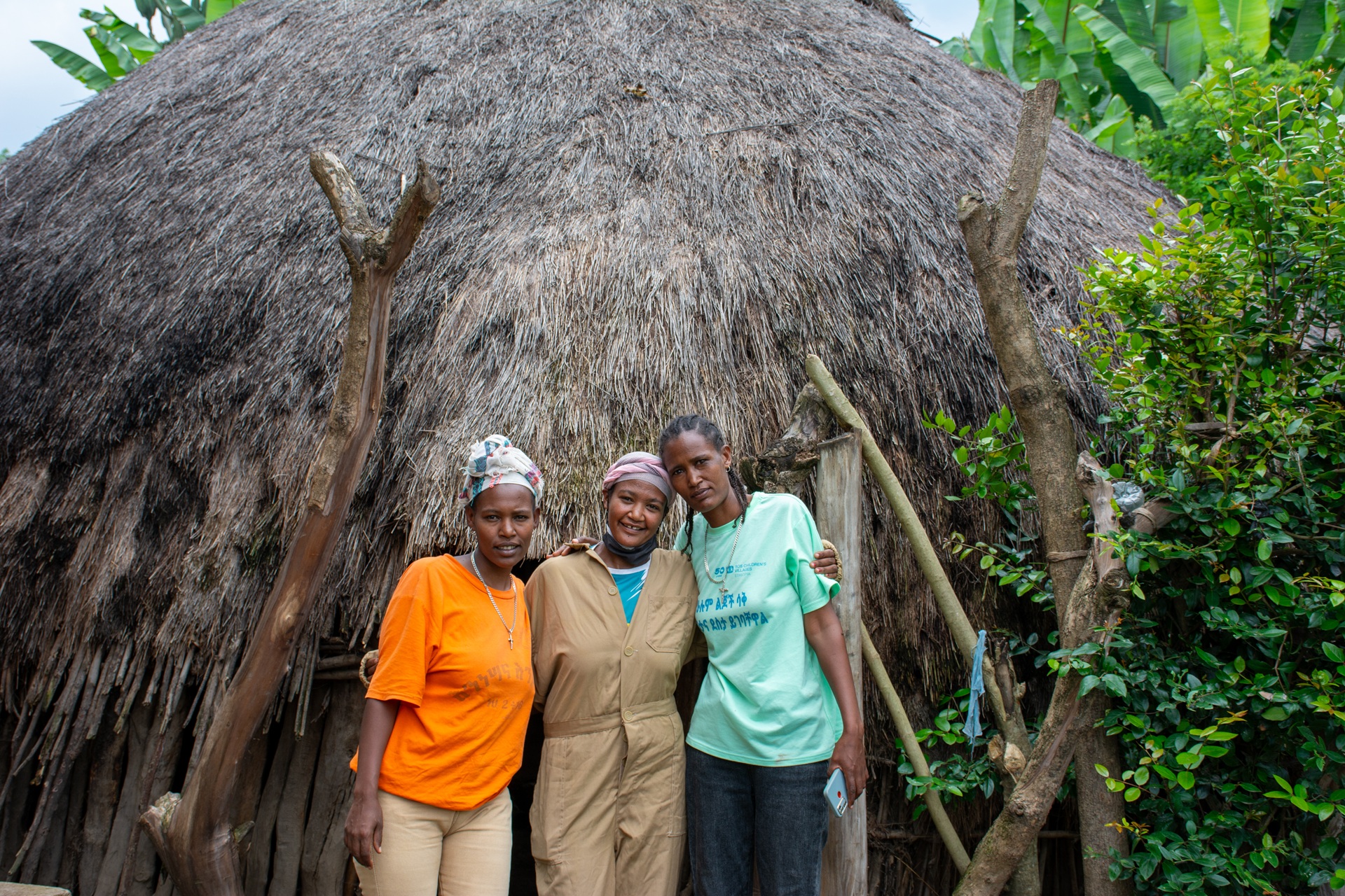 Tre giovani donne stanno a braccetto davanti alla loro azienda.