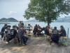 Le persone siedono sulle panchine in riva al lago.