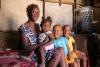 Una donna siede su un divano con i suoi figli.