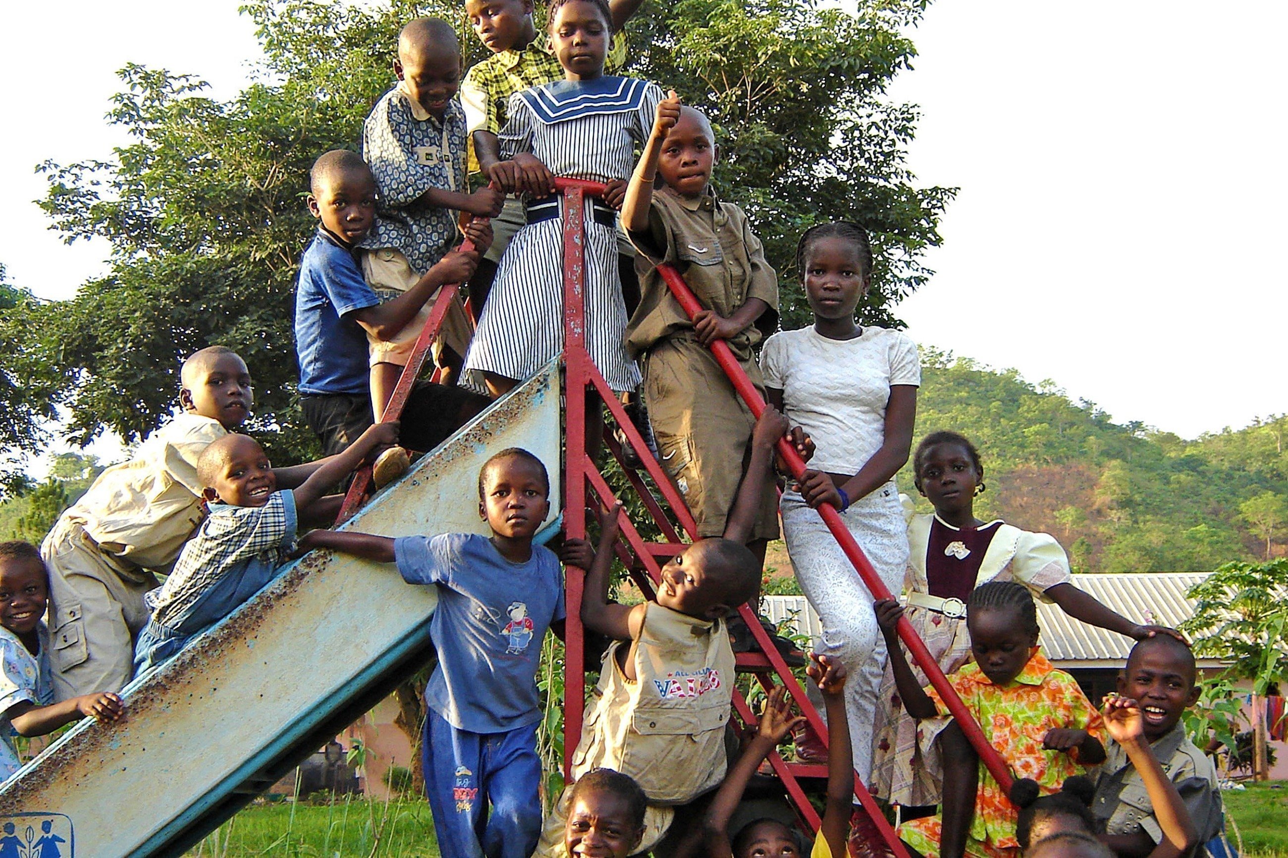 Gruppo di bambini sul bordo di uno scivolo.
