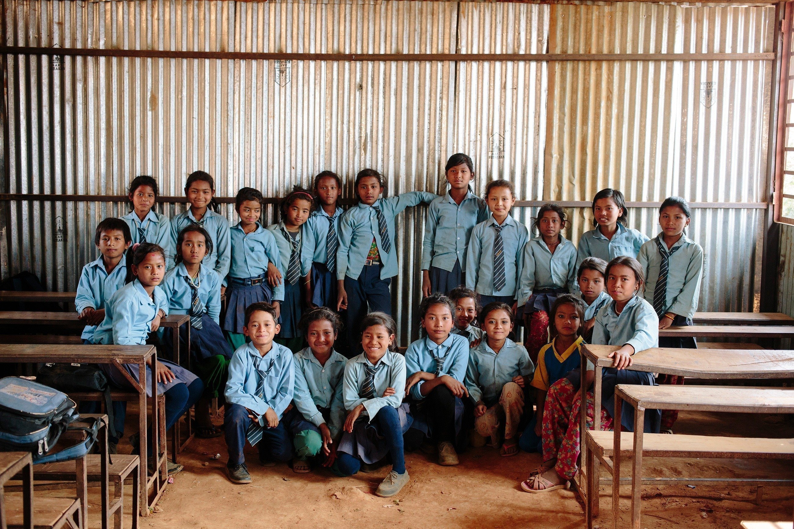 Una classe di bambini in uniforme blu.