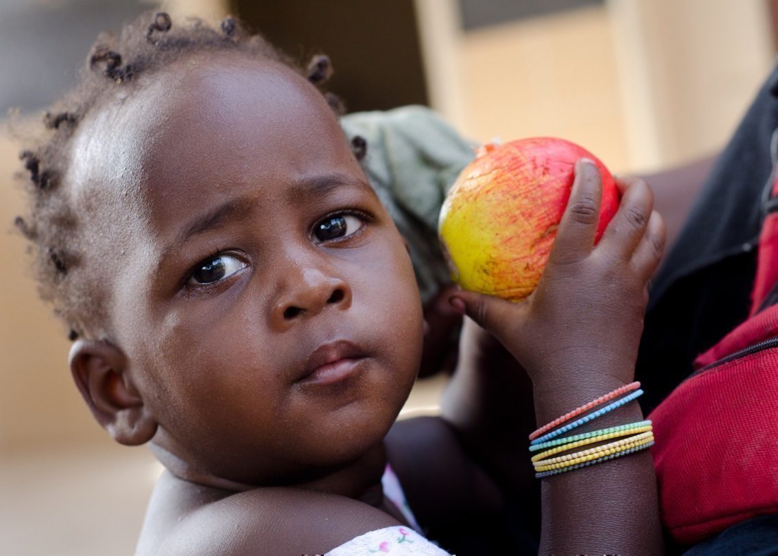 Una bambina tiene una mela in mano.